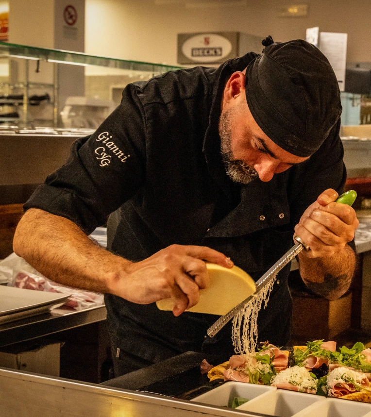 Chef del ristorante pizzeria Magie a Castelvetrano mentre prepara una pizza con farine di grani antichi e ingredienti di qualità | Magie ristorante pizzeria a Castelvetrano
