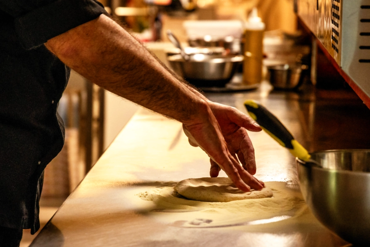 Primo piano dello Chef del ristorante pizzeria Magie a Castelvetrano mentre prepara una pizza con farine di grani antichi siciliani | Magie ristorante pizzeria a Castelvetrano